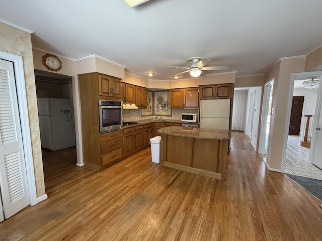 8508 Wellington Ave, Margate, NJ 08402 - kitchen with white appliances, ceiling fan, light wood-style flooring, a sink, and backsplash