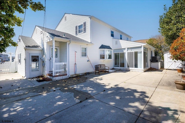 8508 Wellington Ave, Margate, NJ 08402 - back of property with a sunroom, a patio, central AC unit, and a shingled roof