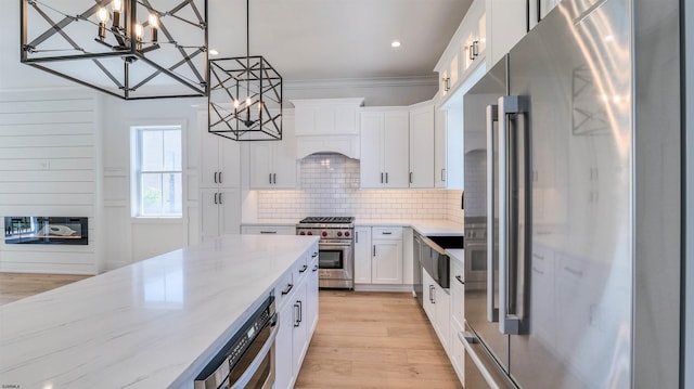 42 E New York Ave, Somers Point, NJ 08244 - kitchen featuring high quality appliances, a chandelier, light stone countertops, white cabinets, and decorative backsplash