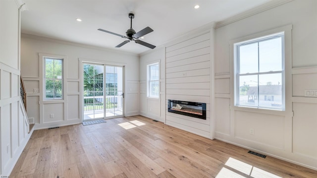 42 E New York Ave, Somers Point, NJ 08244 - unfurnished living room featuring a decorative wall, ornamental molding, light wood-type flooring, a glass covered fireplace, and a ceiling fan