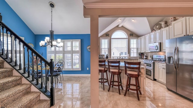 kitchen with stainless steel appliances, vaulted ceiling, a chandelier, healthy amount of natural light, and a breakfast bar