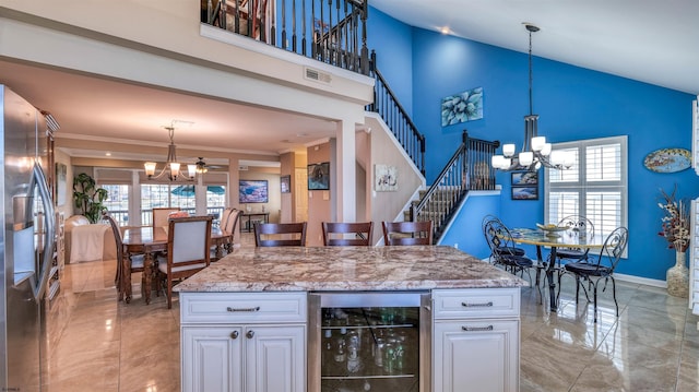 kitchen featuring a chandelier, beverage cooler, stainless steel refrigerator with ice dispenser, light marble finish flooring, and high vaulted ceiling