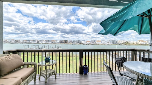 deck featuring a water view and a lawn