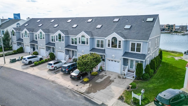 view of front of property featuring a shingled roof, an attached garage, concrete driveway, stucco siding, and a front lawn