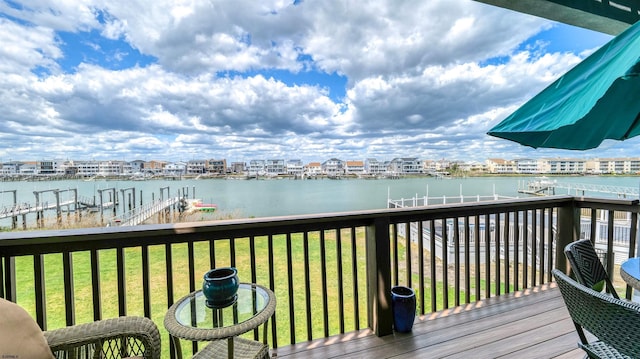 wooden deck with a water view and a yard
