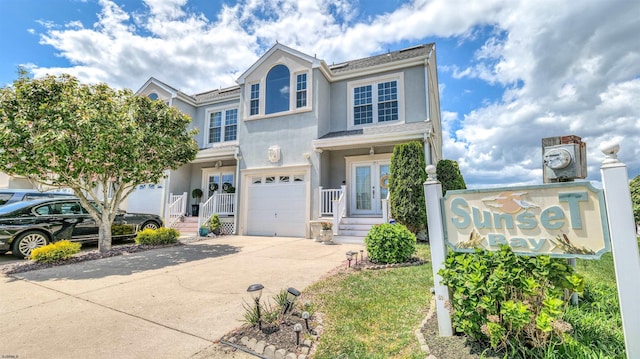 multi unit property featuring stucco siding, driveway, and a garage