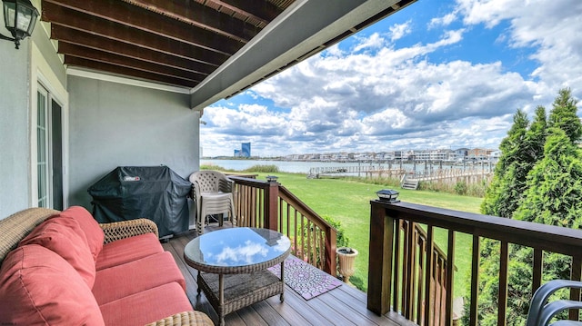 wooden terrace featuring a water view, a grill, and a yard