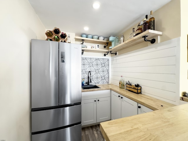 kitchen featuring freestanding refrigerator, a sink, butcher block countertops, open shelves, and dark wood-style floors