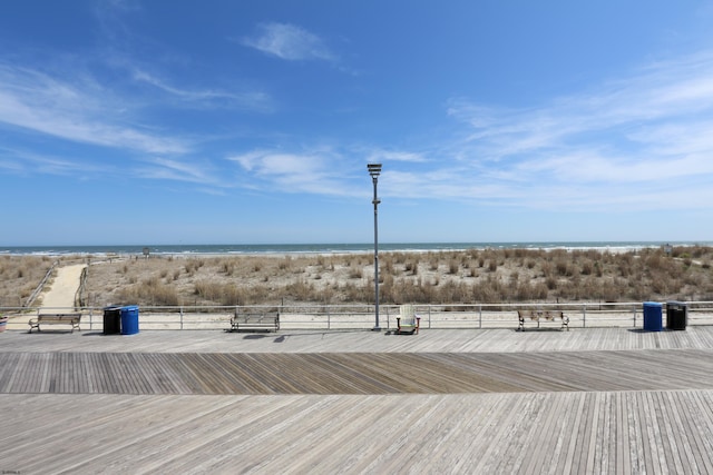 wooden terrace featuring view of water and beach