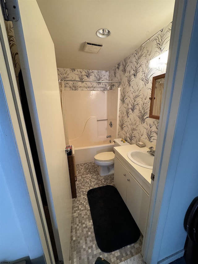 bathroom featuring wallpapered walls, toilet, vanity, tile patterned flooring, and bathtub / shower combination