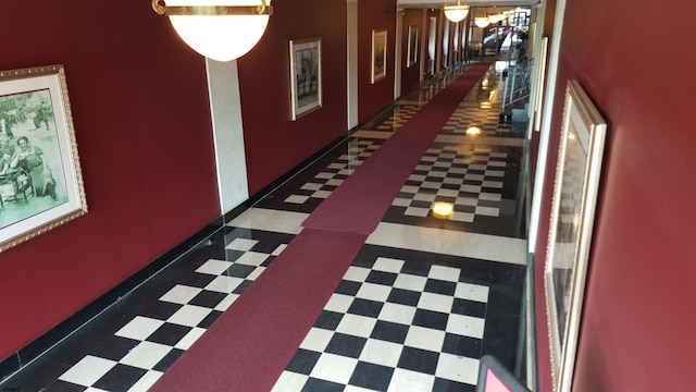 hallway with tile patterned floors and baseboards