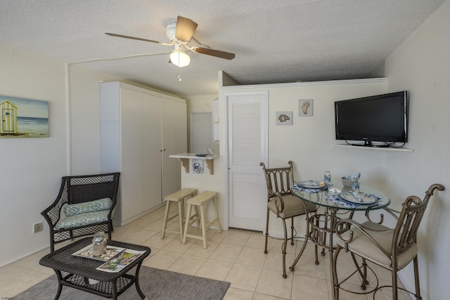 dining room with a ceiling fan, a textured ceiling, and light tile patterned flooring