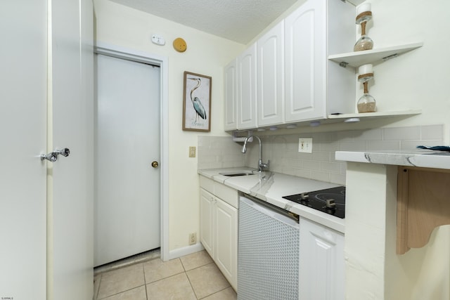 kitchen with dishwasher, a sink, black electric stovetop, and white cabinets