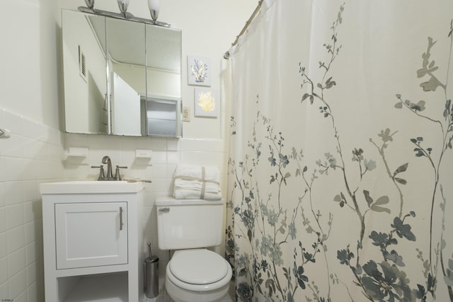 bathroom with toilet, vanity, tile walls, and curtained shower