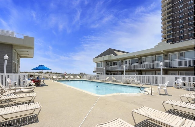 community pool featuring a patio area and fence