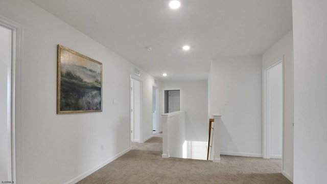 hallway with an upstairs landing, carpet floors, recessed lighting, and baseboards