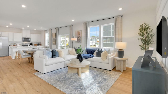 living area with light wood-style flooring and recessed lighting