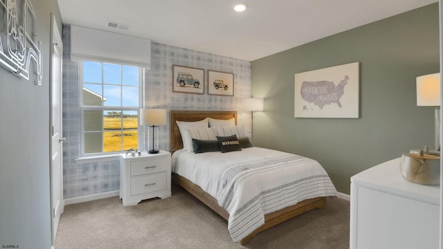 bedroom with light colored carpet, multiple windows, baseboards, and wallpapered walls