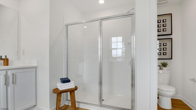 bathroom with a stall shower, baseboards, toilet, and recessed lighting