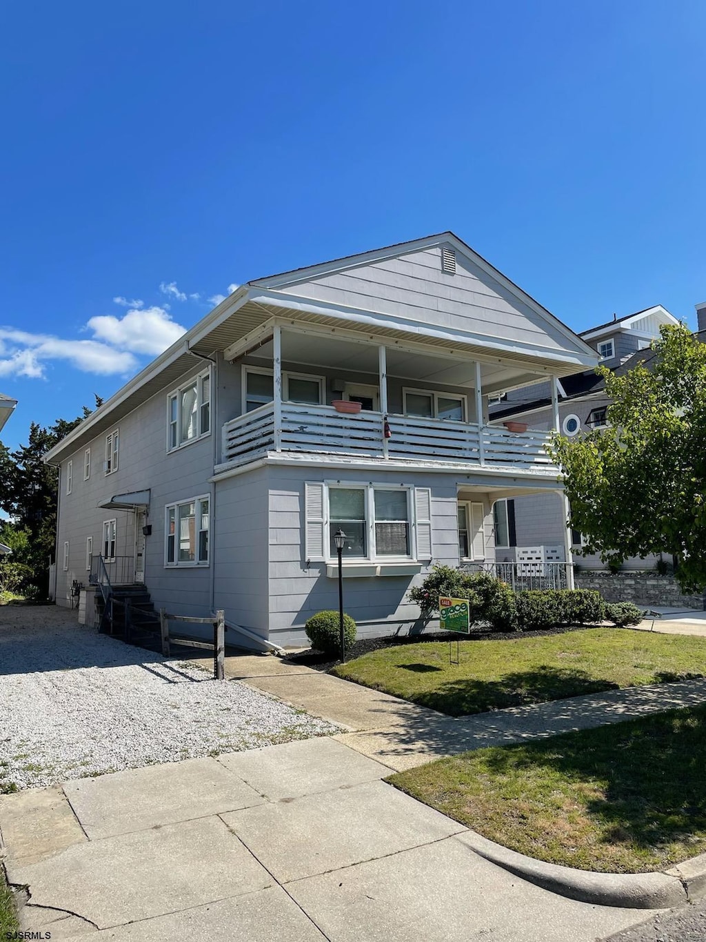 view of property with a balcony and a front yard