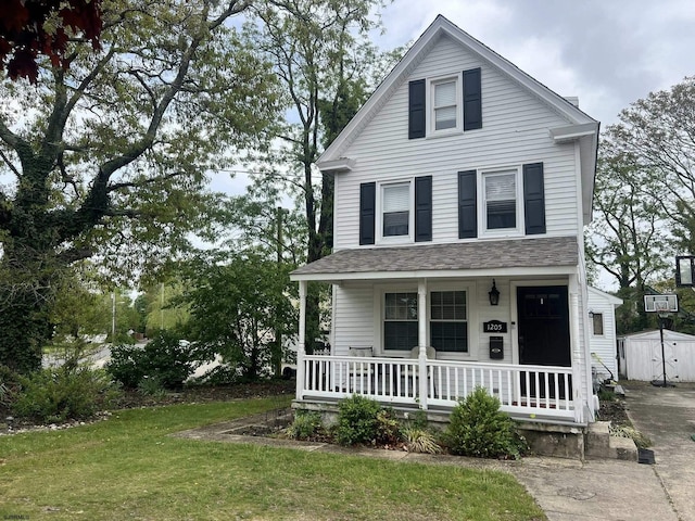 view of front of house with a porch, an outdoor structure, a shed, and a front lawn