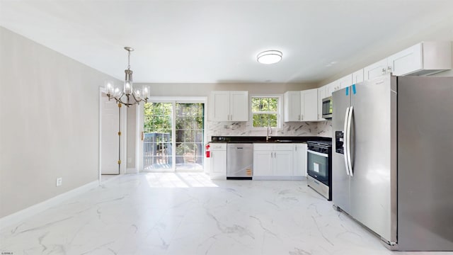 928 S Mill, Vineland, NJ 08360 - kitchen with stainless steel appliances, a chandelier, light marble finish floors, white cabinetry, and decorative backsplash