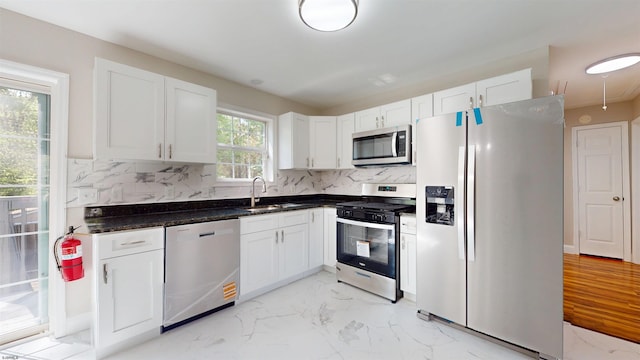 928 S Mill, Vineland, NJ 08360 - kitchen featuring appliances with stainless steel finishes, a sink, light marble finish flooring, white cabinets, and backsplash