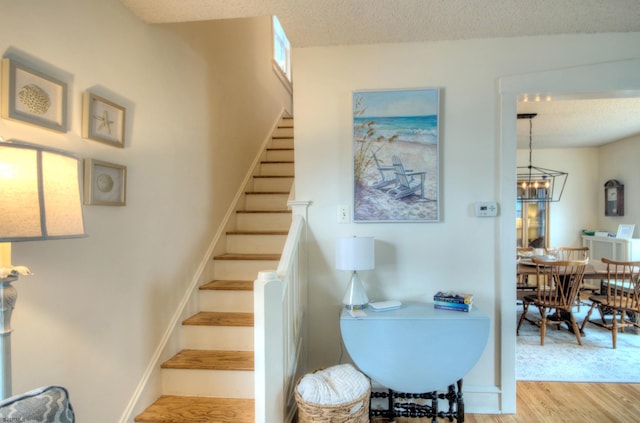 15 N Douglas Ave, Margate, NJ 08402 - staircase featuring wood finished floors, a chandelier, and a textured ceiling