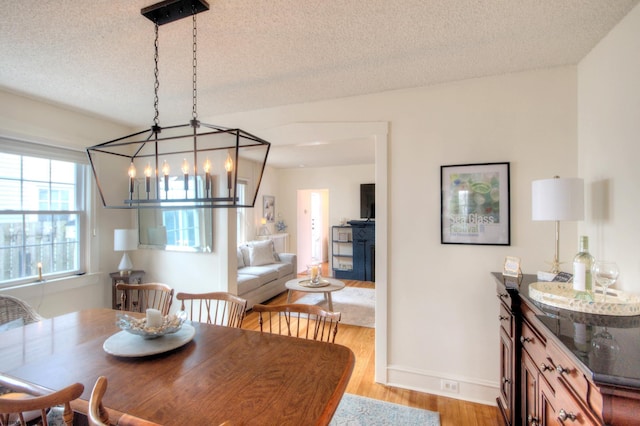 15 N Douglas Ave, Margate, NJ 08402 - dining space featuring a chandelier, light wood-style floors, a textured ceiling, and baseboards