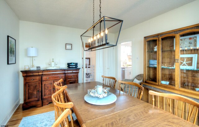 15 N Douglas Ave, Margate, NJ 08402 - dining area featuring light wood-type flooring, a chandelier, and baseboards
