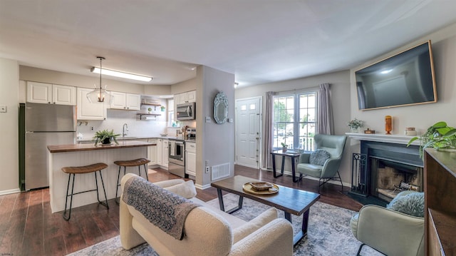 living room with dark wood-style floors, a fireplace, and baseboards