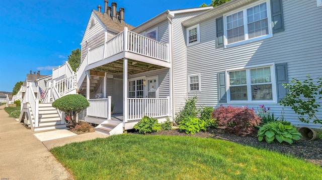 view of front of property featuring stairs, a front yard, and a porch