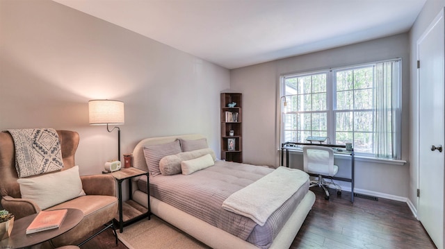 bedroom featuring baseboards and dark wood-style flooring