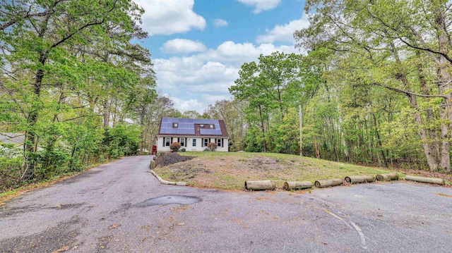 31 English Ln, Egg Harbor Township, NJ 08234 - view of front facade featuring roof mounted solar panels, a wooded view, asphalt driveway, and a front lawn