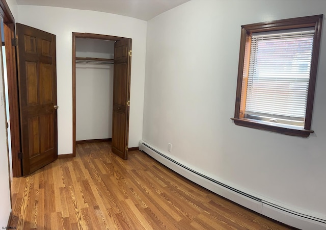 2910 Sunset Ave, Atlantic City, NJ 08401 - unfurnished bedroom featuring a baseboard heating unit, light wood-type flooring, a closet, and baseboards