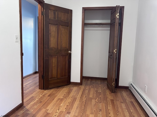 2910 Sunset Ave, Atlantic City, NJ 08401 - unfurnished bedroom with a baseboard heating unit, light wood finished floors, a closet, and baseboards