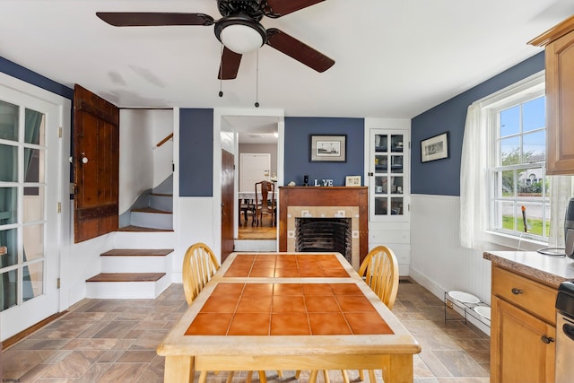 1224 Front St, Mauricetown, NJ 08329 - dining area with stone finish flooring, wainscoting, stairway, and ceiling fan