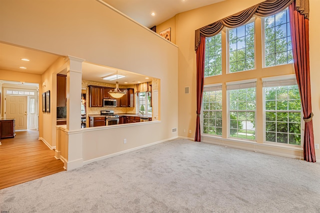 31 Leah Ct, Hammonton, NJ 08037 - unfurnished living room featuring light carpet, recessed lighting, a high ceiling, baseboards, and ornate columns