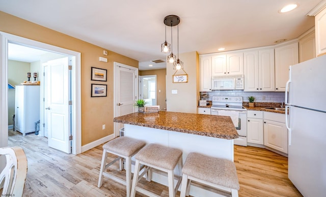 802 Coolidge Rd Unit 2, Ocean City, NJ 08226 - kitchen featuring white appliances, light wood finished floors, dark countertops, a kitchen island, and decorative backsplash