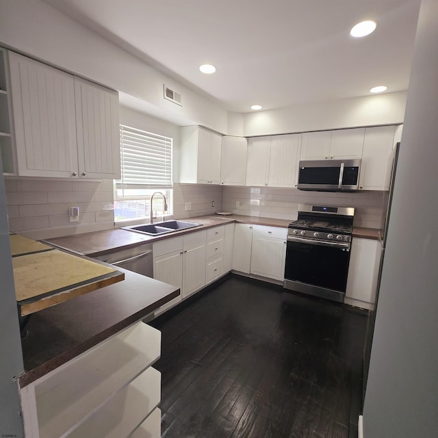 206 N S Carolina Ave, Atlantic City, NJ 08401 - kitchen featuring appliances with stainless steel finishes, a sink, dark wood-style flooring, white cabinetry, and tasteful backsplash