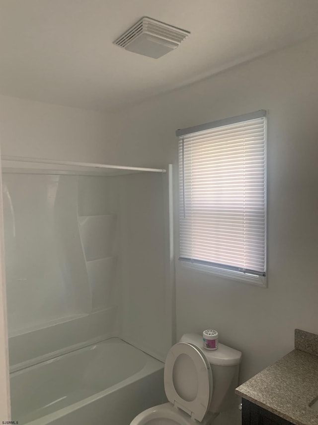 bathroom with toilet, vanity, and bathtub / shower combination