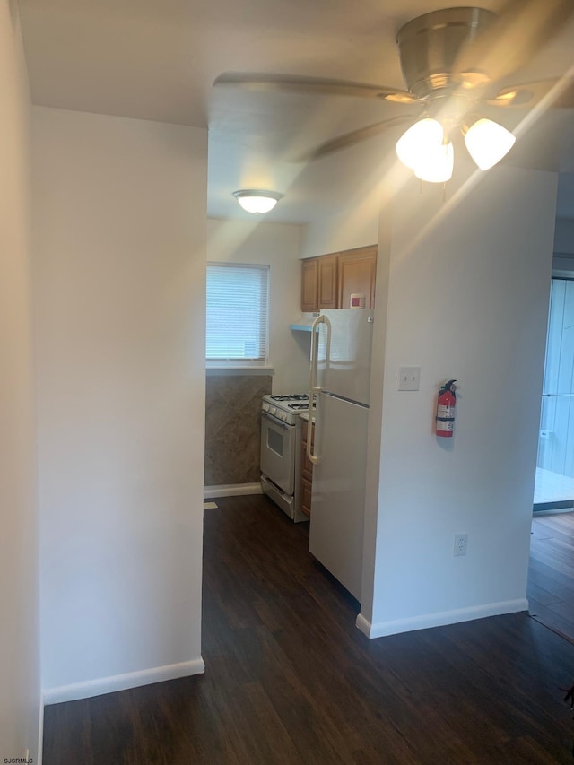 kitchen featuring white appliances, baseboards, a ceiling fan, and dark wood-style flooring