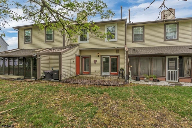 669 E Lake Front Cir Unit 669, Smithville, NJ 08205 - rear view of property with a sunroom, a chimney, a lawn, and cooling unit