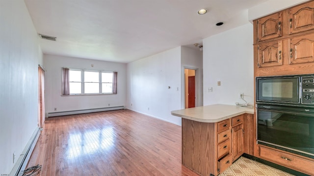 711 N Ohio Ave, Atlantic City, NJ 08401 - kitchen featuring black appliances, a baseboard radiator, a peninsula, and light countertops
