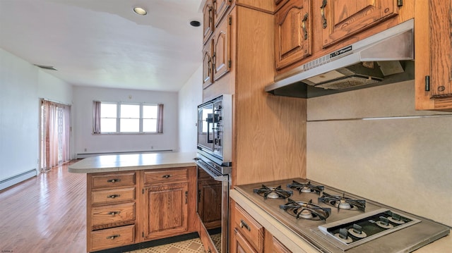 711 N Ohio Ave, Atlantic City, NJ 08401 - kitchen featuring under cabinet range hood, appliances with stainless steel finishes, brown cabinetry, light countertops, and light wood-type flooring