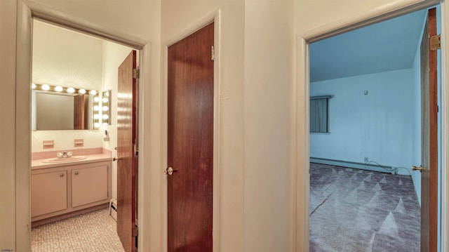711 N Ohio Ave, Atlantic City, NJ 08401 - hallway featuring a sink, baseboard heating, light carpet, and a baseboard radiator