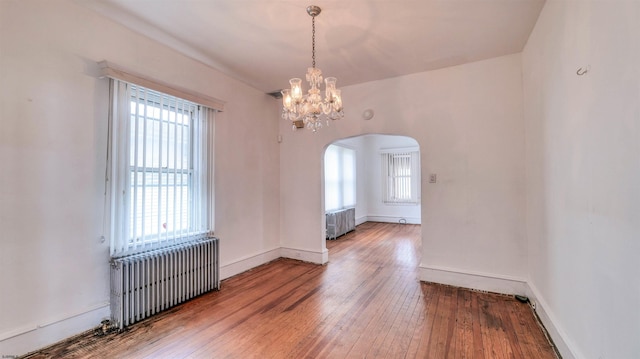 711 N Ohio Ave, Atlantic City, NJ 08401 - spare room with radiator heating unit, radiator, arched walkways, and plenty of natural light