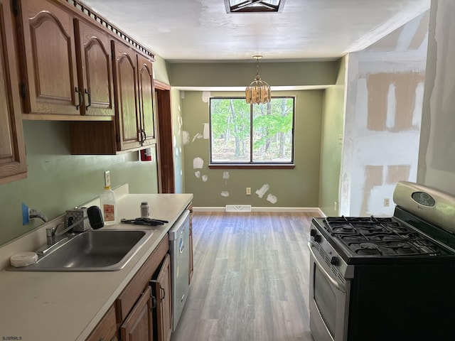 205 Country Ln, Galloway Township, NJ 08205 - kitchen featuring stainless steel appliances, a sink, light wood-style floors, light countertops, and hanging light fixtures