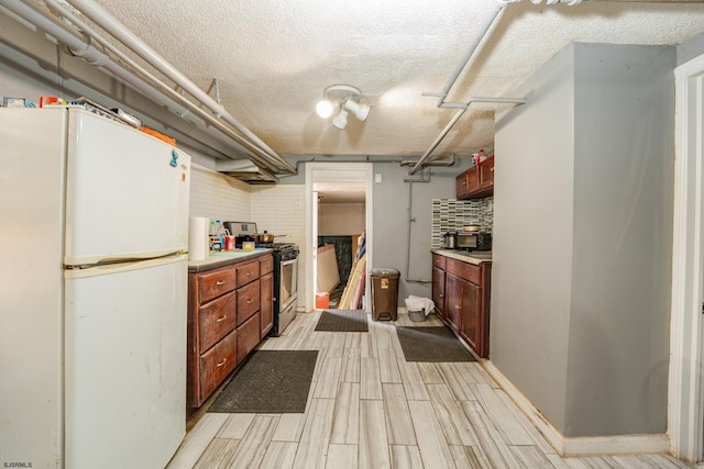 32 N Florida Ave, Atlantic City, NJ 08401 - kitchen with freestanding refrigerator, gas stove, wood tiled floors, a textured ceiling, and light countertops