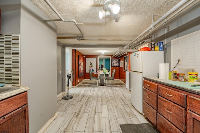 32 N Florida Ave, Atlantic City, NJ 08401 - kitchen featuring freestanding refrigerator, light wood-type flooring, a textured ceiling, baseboards, and light countertops